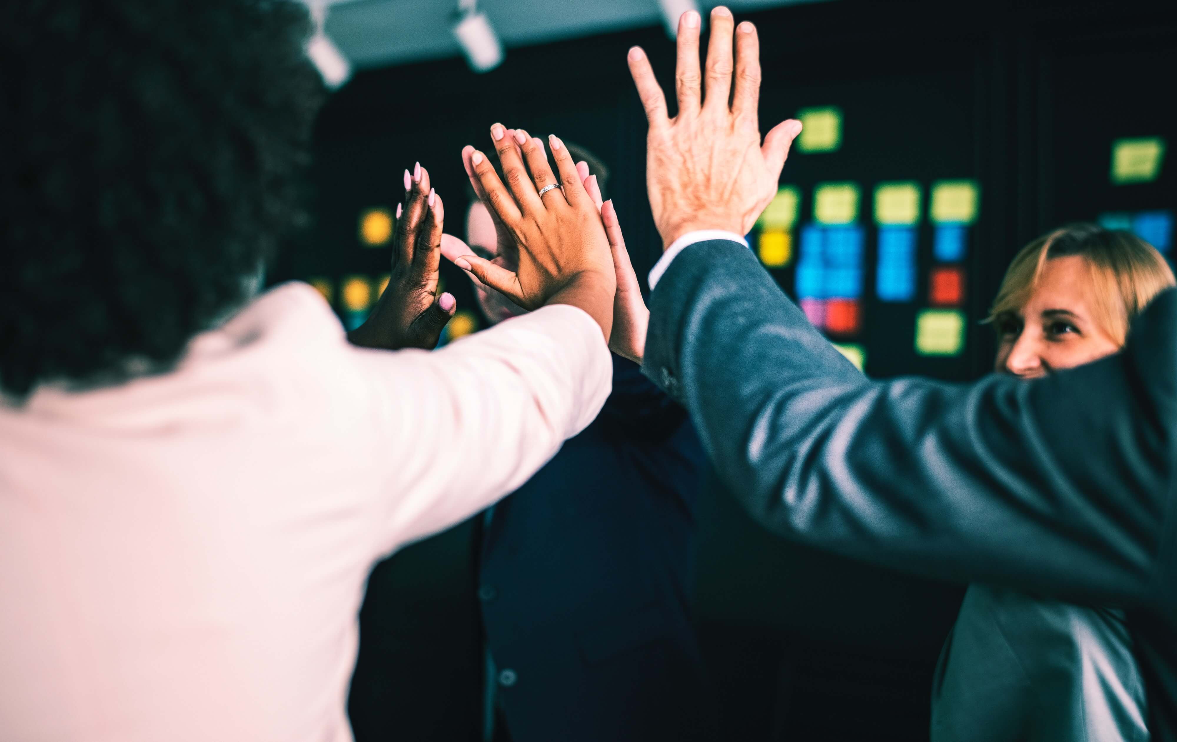 multicultural group high-fiving
